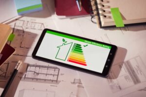 Energy,Efficiency,Screen,On,Cellphone,Leaning,On,Drawings,And,Blueprints