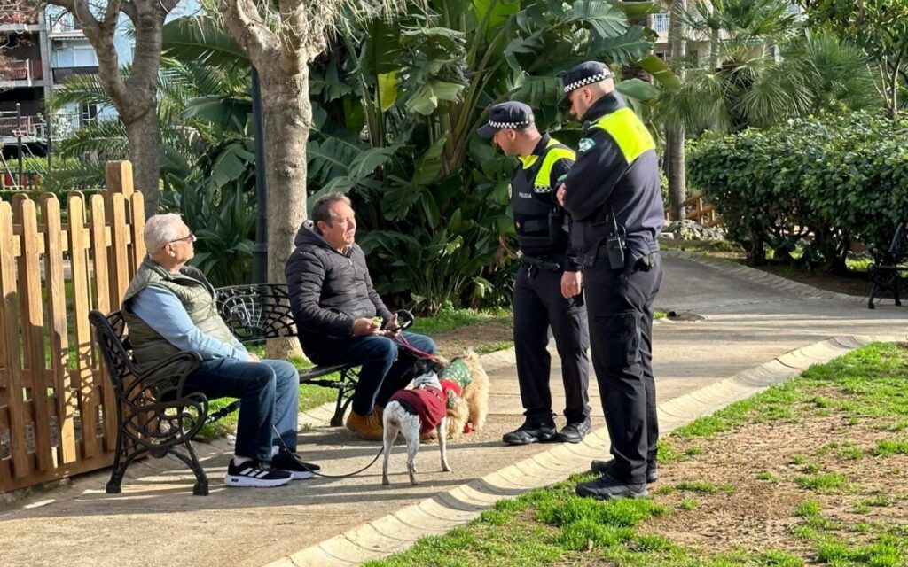 Dos agentes de Policia Local dialogan con unos